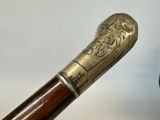 an old walking stick with a carved handle and a wooden handle