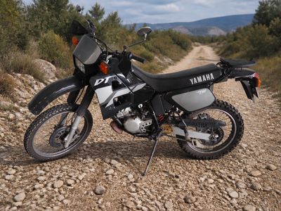 une moto garée sur le bord d'un chemin de terre