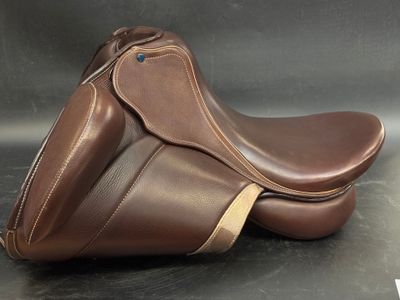 brown leather saddle on a black surface with a black background