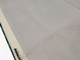 a white sheet of fabric on the ground with a black border