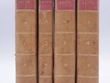 three old books sitting on top of each other on a white surface