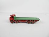 green and red toy truck sitting on top of a white surface