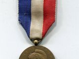 une vieille médaille entourée d'un ruban rouge, blanc et bleu