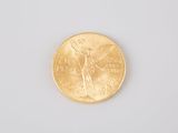 a close up of a gold coin on a white surface