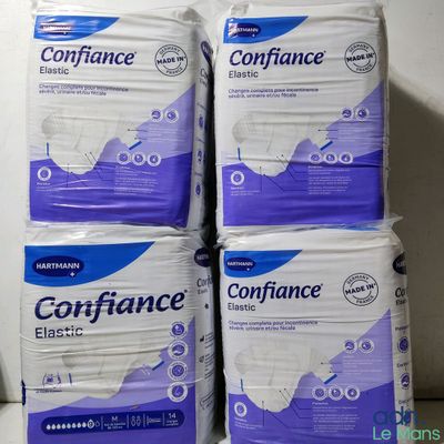 quatre paquets de serviettes hygiéniques sont empilés les uns sur les autres
