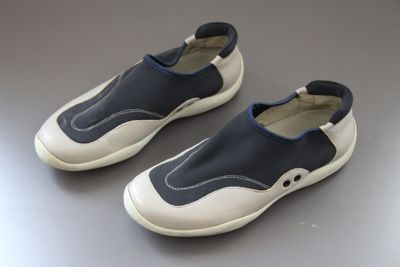 pair of blue and white shoes sitting on top of a gray surface