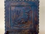 une photo d'une plaque métallique sur laquelle figure un oiseau