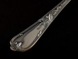 a silver spoon that is sitting on a black surface