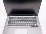 a silver laptop with a black keyboard on a white surface
