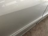 a close up of a white car with scratches on the door