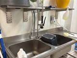 une cuisine avec un évier et une serpillière posée sur le plan de travail