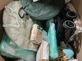 a cardboard box filled with items that include toiletries, toilet paper, and other items