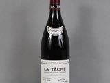 bottle of red wine on a glass table with a gray background