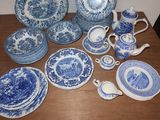 many blue and white plates and cups on a table