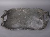 a silver tray with a statue on it on a table