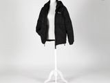 une veste noire posée sur un mannequin, sur fond blanc