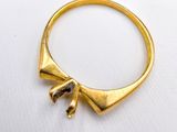 an image of a gold ring with a bow on top of it