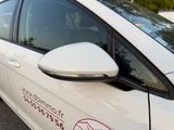 a white car that has a no parking sign on the side of it