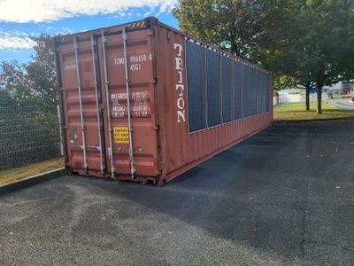 a red shipping container sitting on the side of the road