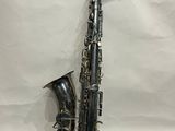 un saxophone argenté posé sur une feuille de papier blanche