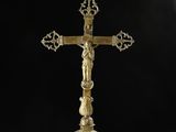 a gold cross on a black background with smoke coming out of it