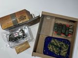 a box with a toy army vehicle and other items in it