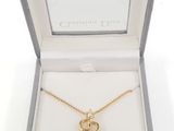 a close up of a necklace in a box on a white surface