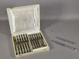 des couverts dans un coffret contenant une paire de ciseaux et une paire de pinces