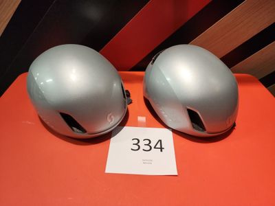 une paire de casques argentés posés sur une table orange