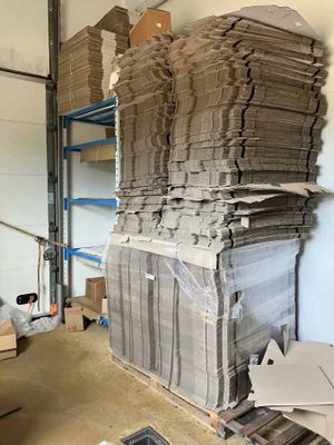 a large stack of cardboard sitting on a pallet in a warehouse