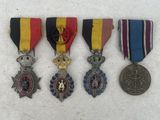 three medals and a medal are sitting on a white surface