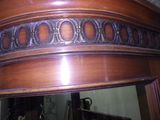 a mirror that has a wooden frame on top of it
