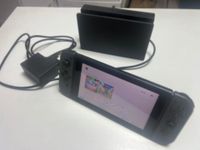 Une NINTENDO Switch avec son doc (démarre).