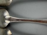 three spoons that are sitting next to each other on a table