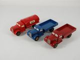 quatre camions miniatures posés les uns à côté des autres sur une surface blanche
