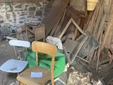 une chaise et une table au milieu d'une pièce encombrée de bric-à-brac