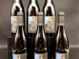 six bouteilles de vin sont alignées sur une table