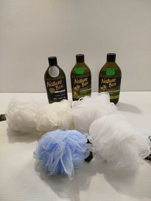 trois bouteilles de shampoing, une boule de savon et une éponge posées sur un plan de travail