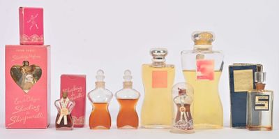 de nombreux flacons de parfum alignés sur une table