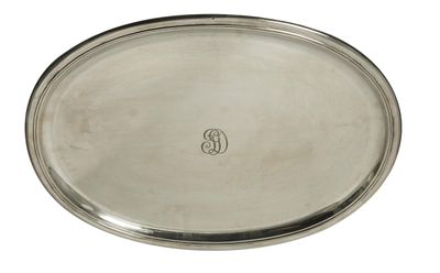 un plateau ovale en argent portant un monogramme au fond