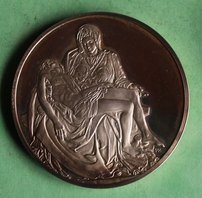 a silver coin with a picture of a woman and a dog on it