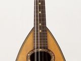 une mandoline posée sur un support, sur une surface blanche