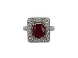 gros plan d'une bague avec une pierre rouge entourée de diamants blancs