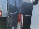 many white vans parked in a row in the grass