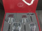 quatre verres à vin dans une boîte rouge ornée d'un ruban blanc