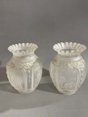 deux vases blancs posés l'un à côté de l'autre sur une table