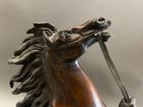 a statue of a horse holding a stick in its mouth