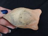 a person holding a piece of pottery in their hand