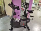 un vélo d'appartement dans une salle de sport aux murs roses