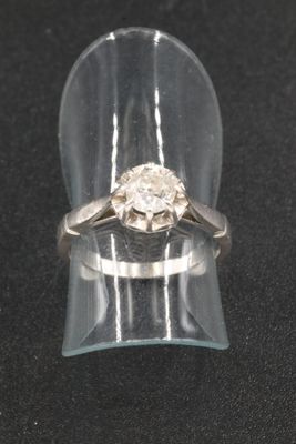 an image of a diamond ring sitting on top of a clear ring holder
